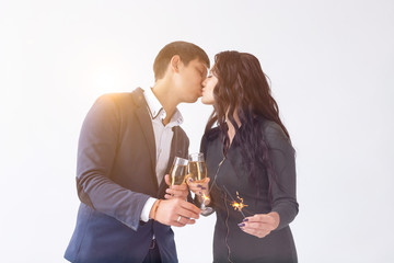 Valentines day and date concept - Couple with champagne glasses and sparklers on white background