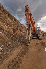 Hydraulic hammer working on the construction of a road