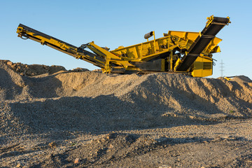 Mechanical conveyor belt to pulverize rock and stone and generate gravel