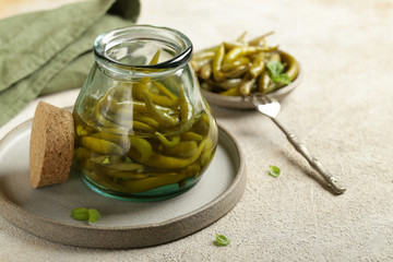 pickled green hot peppers in a wooden bowl
