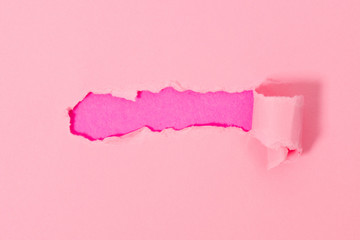 Top view of pink torn paper on pink background.