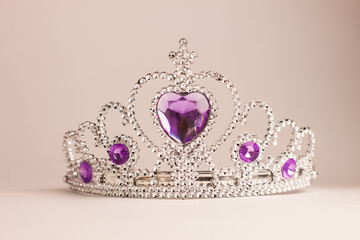 Silver crown with violet heart diamonds isolated on light background. Purple crystal headband....