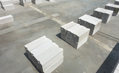 White foamed lightweight concrete block laying in stacks on the concrete floor with negative space