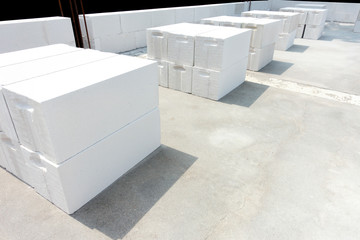 White foamed lightweight concrete block laying in stacks on the concrete floor with negative space