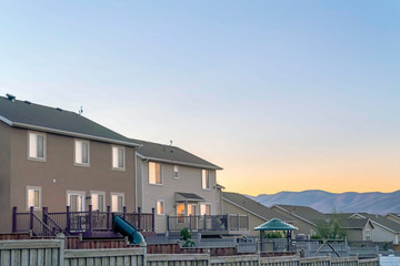 Homes with wooden fences and stairs going up to balconies with glass doors