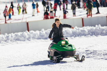 Boy driving snowmobile in a winter landscape