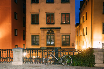 Fototapeta na wymiar Stockholm, Sweden. Night View Of Traditional Stockholm Street. Residential Area, Cozy Street In Downtown. Osterlanggatan Street In Historical District Gamla Stan. Parked Bicycle Bike In European City