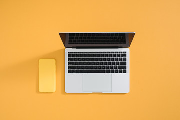 Fototapeta na wymiar Smartphone and laptop on minimal business desk background