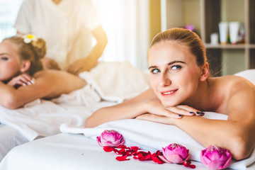 Obraz na płótnie Canvas Beautiful young attractive Caucasian woman having body massage by Thai Masseur in spa salon. Beauty treatment and body care concept.