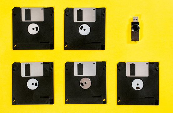 Floppy disk in row with standing out usb memory flash drive. Retro vs modern style