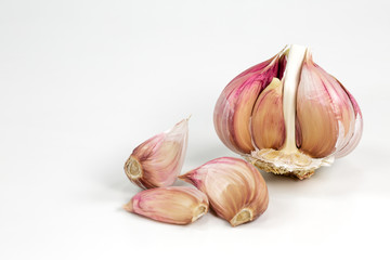 a opened semi-peeled garlic bulb and cloves isolated on white background with copy space