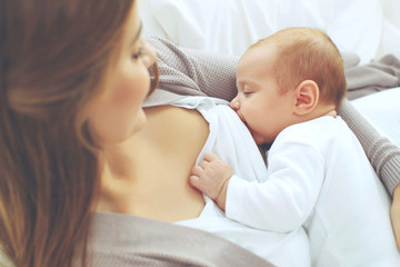 A woman is breastfeeding a baby.  - 314035887