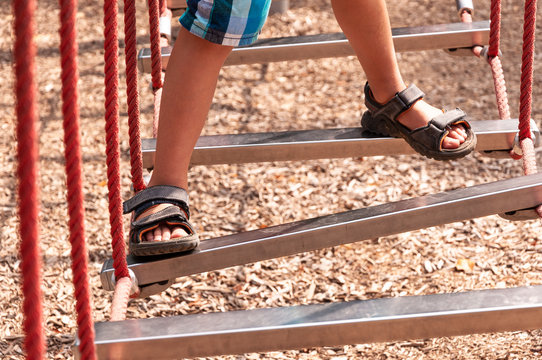 Kind im Sommer balanciert &uuml;ber Hindernisse eines Geschicklichkeitsparcours