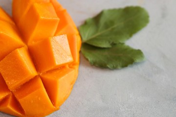 Mango tropical fruit with green leaf on abstract background, top view
