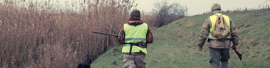 Hunting period, autumn season open. A hunter with a gun in his hands in hunting clothes in the...