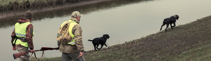 Hunting period, autumn season open. A hunter with a gun in his hands in hunting clothes in the...