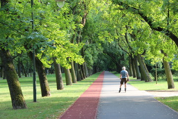 Beautiful city park with treadmill and man running on roller skates