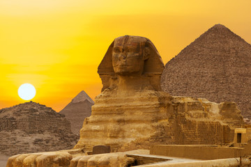 Sphinx against the backdrop of the great Egyptian pyramids. Africa, Giza Plateau.	 - obrazy, fototapety, plakaty
