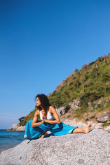 jana shirshasana on a rock early morning near the sea