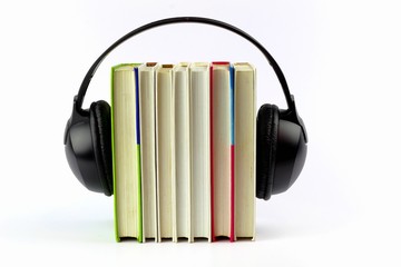 Audiobook concept. Headphones put on old books. Learning and receiving information.