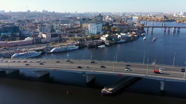 Cargo barge sailing under the Havansky bridge. City traffic on the bridge.