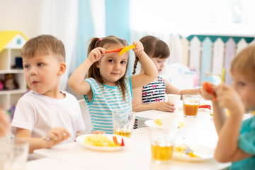 Children group have a lunch in the kindergarten - obrazy, fototapety, plakaty