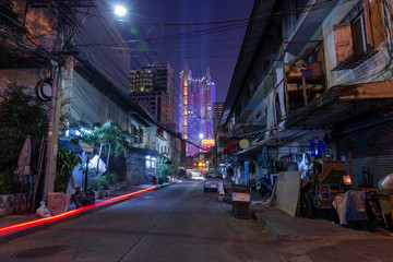Car Lights passing by a small street in bangkok - obrazy, fototapety, plakaty