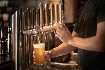 Barman who is tapping a beer