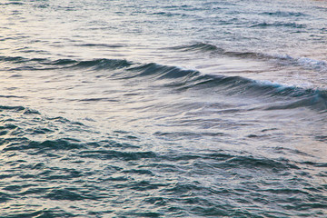 Clear water texture in blue. Background of the ocean and the sea backlit by the sun.