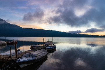 Obraz na płótnie Canvas A beautiful sunrise at a Lake Bratan with boats in foreground. Bali island, Indonesia.
