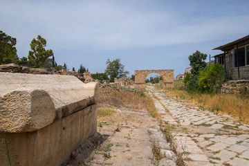 Fototapeta na wymiar A sarcophagus and the Byzantine road. Al-Bass Tyre necropolis. Roman remains in Tyre. Tyre is an ancient Phoenician city. Tyre, Lebanon - June, 2019