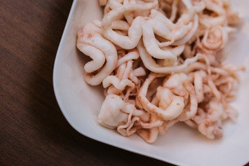 White plate with white octopus tentacles. Seafood salad. Asian cuisine