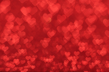 The bokeh texture in the form of many small hearts on a red background. Valentine's day concept.