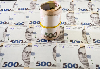 Rolled up Ukrainian money with face value of 500 hryvnia. Hryvnia background ..