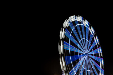 Long exposure of ferris wheel illuminated at night
