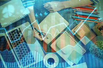 Financial chart drawn over hands taking notes background. Concept of research. Double exposure