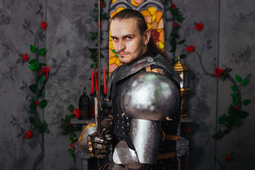 Fototapeta na wymiar Portrait of a medieval knight with a two-handed sword. Warrior in the studio on a dark background.