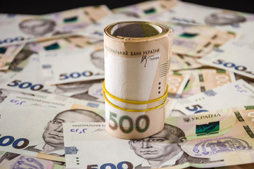 Rolled up Ukrainian money with face value of 500 hryvnia. Hryvnia background ..