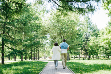 Middle-aged married couple walking in the park together.