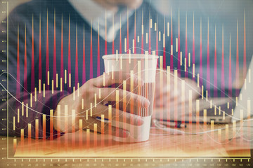 Forex graph with businessman working on computer in office on background. Concept of hardworking....