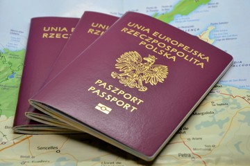 Three Polish passports on the map - travel concept. International travel documents issued to...
