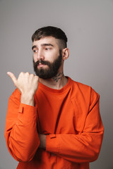 Obraz premium Image closeup of young bearded man pointing finger at copyspace