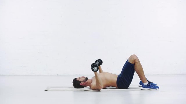 sportsman exercising with dumbbells on white background