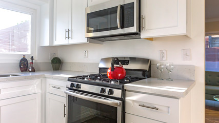 Fototapeta premium Panorama Stove with red kettle in the kitchen