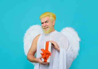 Cupid angel with present box. Happy Valentines Day. Smiling man in angel costume. Cupid. Amour....