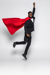 Young african businessman jump for flight hero with fist up isolated on white background