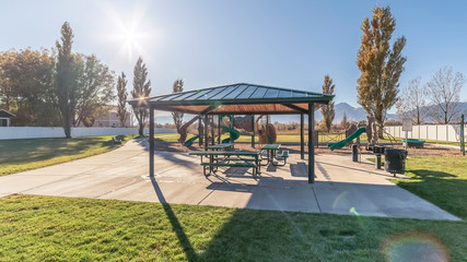 Obraz premium Panorama frame Covered picnic tables and benches near sunrise