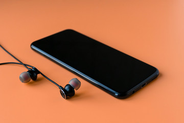 Black wireless bluetooth headphones for the phone on an orange background. Headset for the phone..