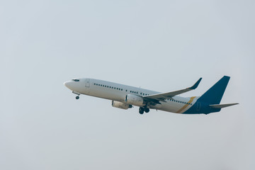 Fototapeta na wymiar Low angle view of jet plane taking off in cloudy sky