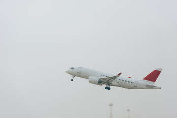 Commercial jet plane taking off with cloudy sky at background